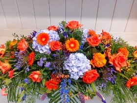 Orange and blue casket spray