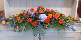 Orange and blue casket spray